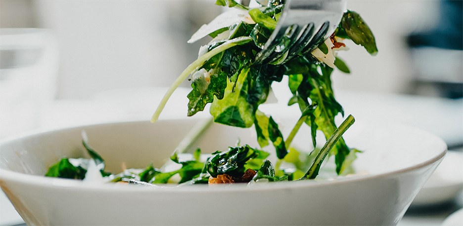 A bowl of salad and other healthy leafy greens. 