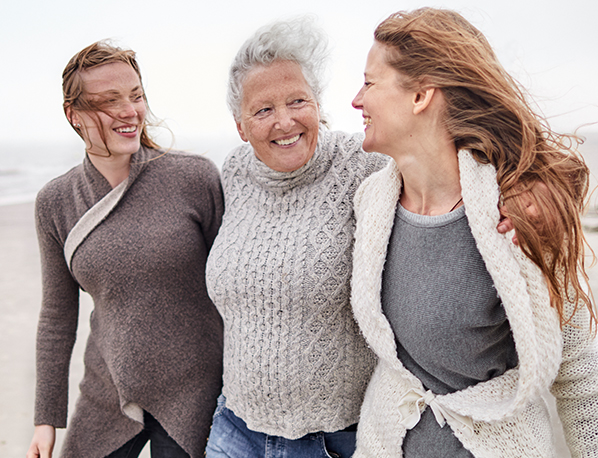 Three women walk together along a beach and discuss their game plan for IBS-C (Irritable Bowel Syndrome with Constipation). 