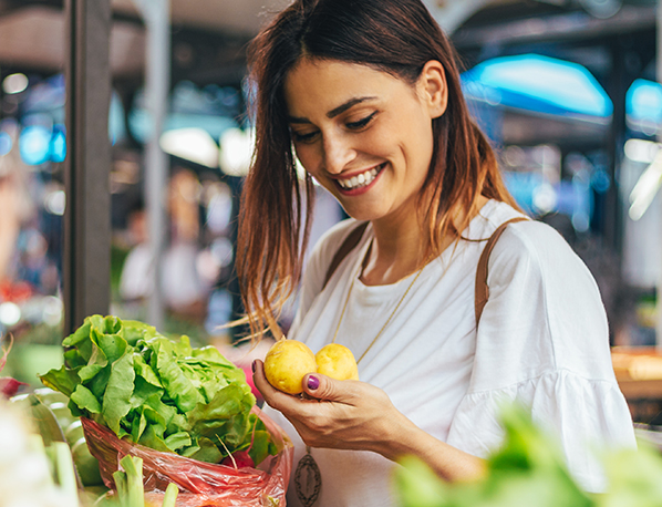 shops at a local farmers market for Low FODMAP foods. 